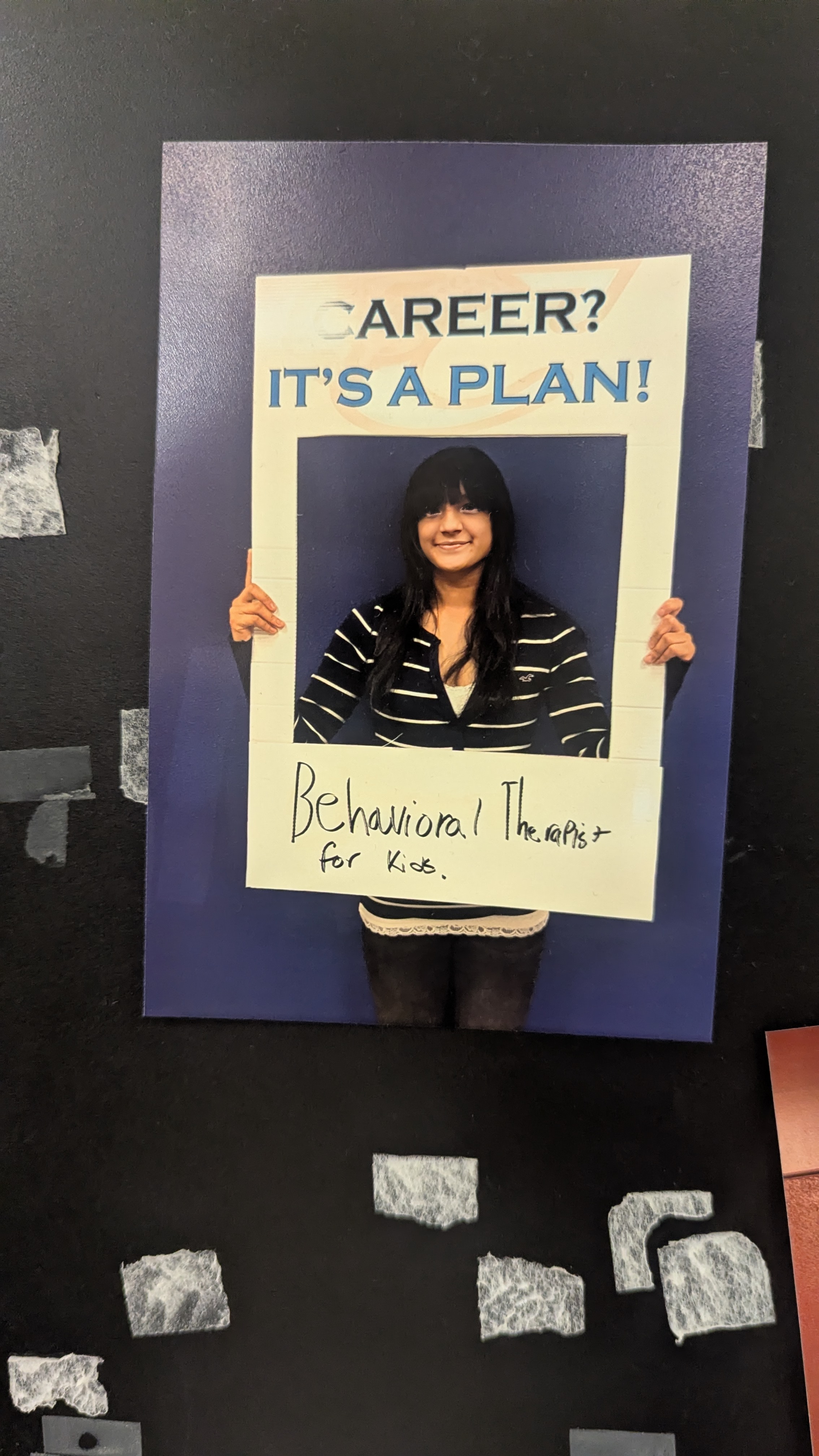 Lu holding her 'Career? It's a plan! Behavioral Therapist for Kids' sign